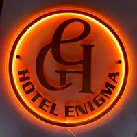 Warm backlit circular logo sign fabricated for Hotel Enigma