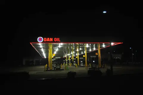 Dan Oil station canopy glowing at night with red LED trim