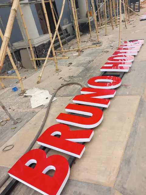 Giant fabricated red letters for Bruno Hotels laid out before installation