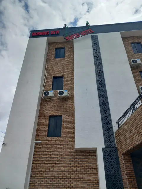 Installers hoisting the Suites Hotel letter section up the facade of Morning Dew Suites Hotel in Owerri