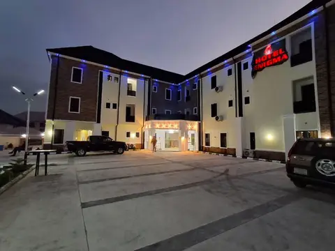 Hotel Enigma facade at night with red LED sign and blue accent lighting