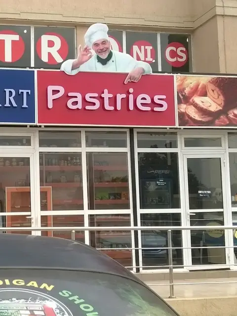 Infinimart Pastries storefront lightbox signage by day